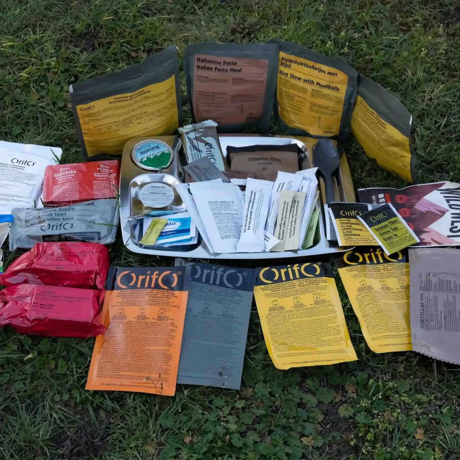 Ración Operacional Holandesa ORP 2024 con componentes y papeles variados sobre césped