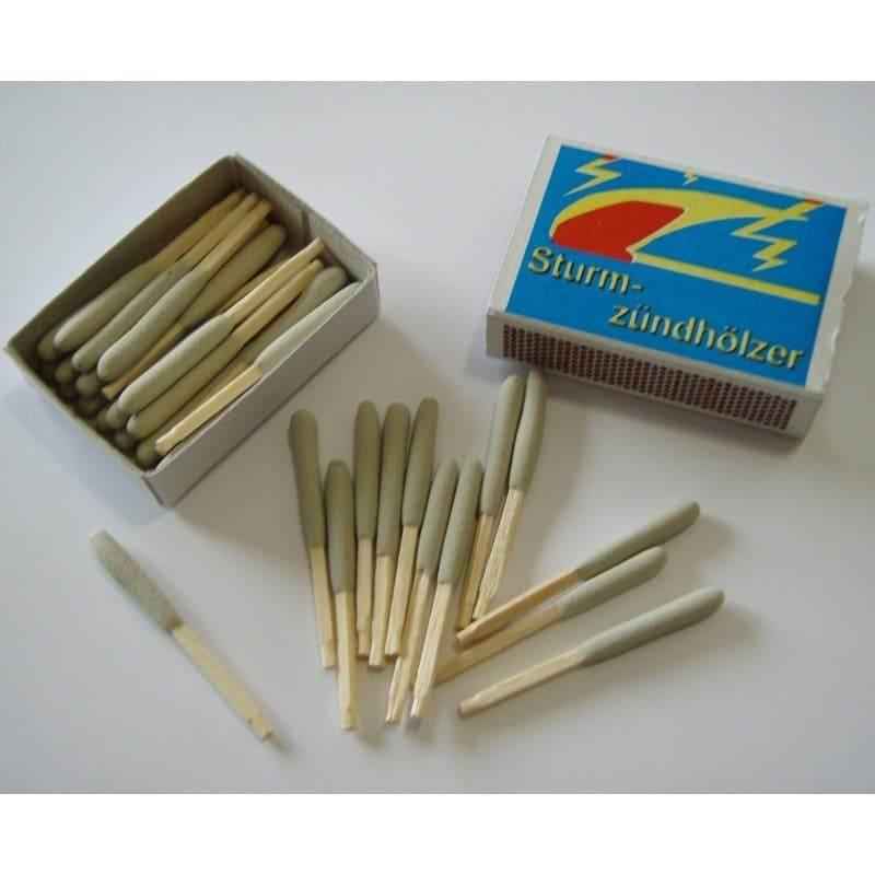 Caja de cerillas antitormenta abierta con cerillas y caja azul cerrada