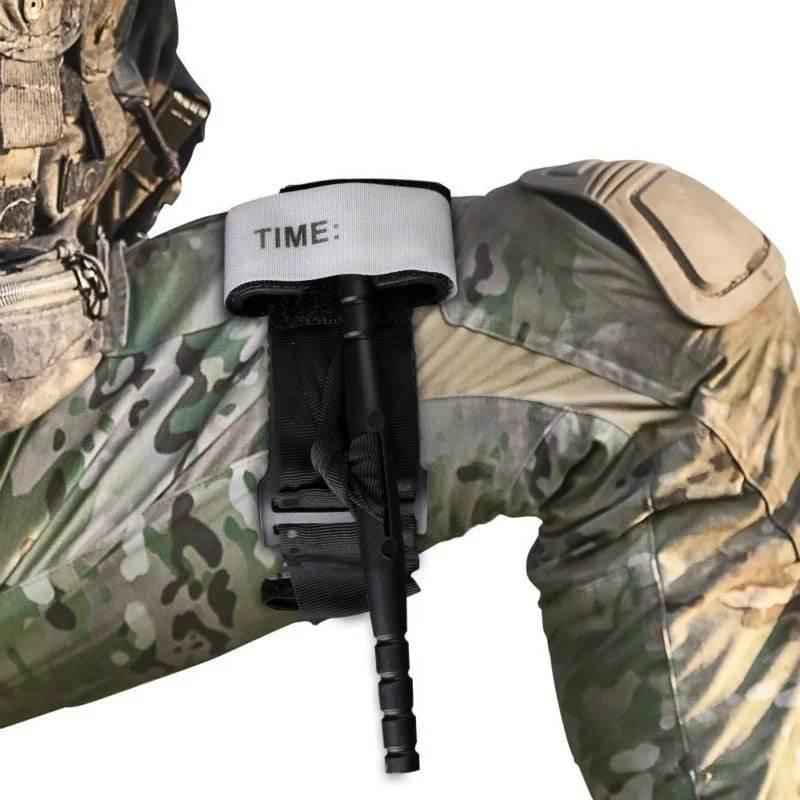 Torniquete de emergencia en uniforme camuflado, correa negra y varilla con almohadilla